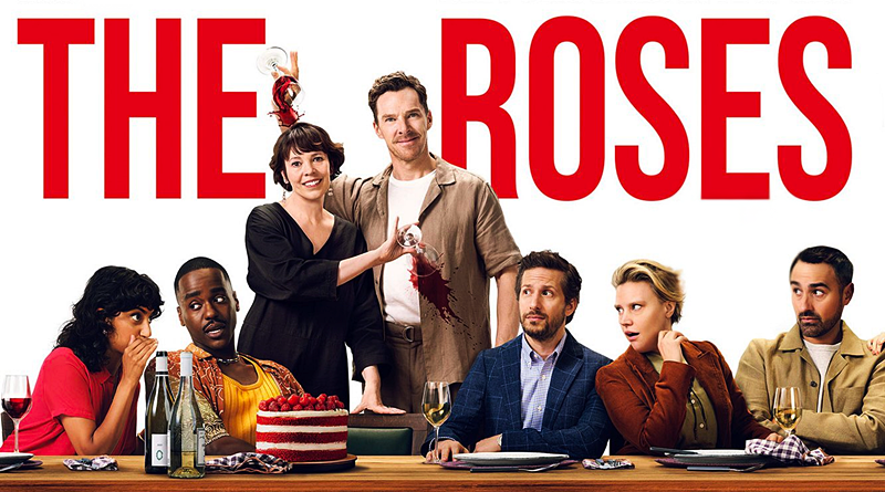 Film promotional image for "The Roses". Bold red text reading "THE ROSES" dominates the top of the image. Below are six people seated at a dinner table looking variously awkward, shocked, or uncomfortable. A woman in black holds a wine glass aloft while a man in beige stands beside her with wine stains down his front. The table is laden with wine bottles, glasses, and a red velvet cake. The composition suggests a dinner party gone spectacularly wrong.