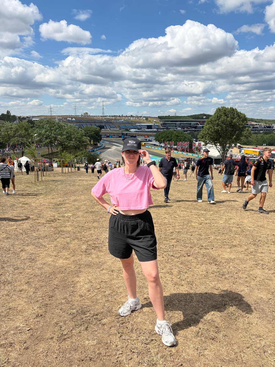 Woman standing on a dusty hill during Formula One race