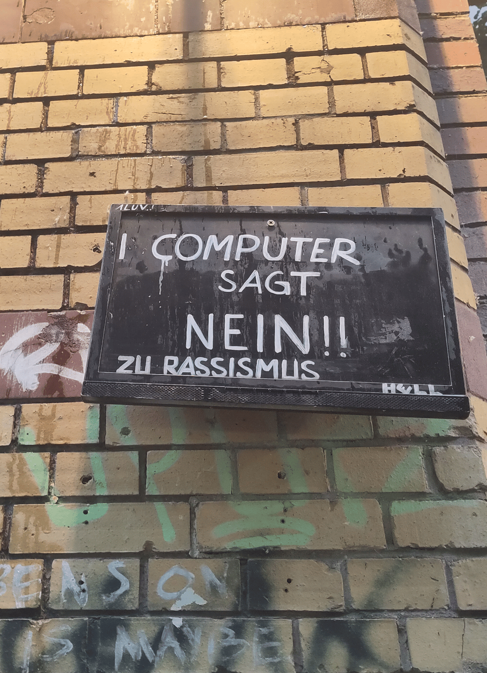 Klinkerwand, darauf ein Schild, auf dem steht "Computer sagt nein!! zu Rassismus"