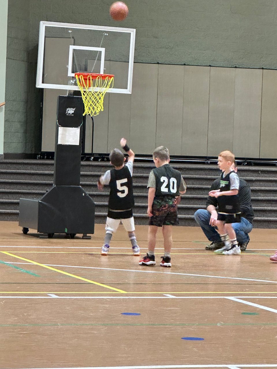 A group of young kids playing basketball.