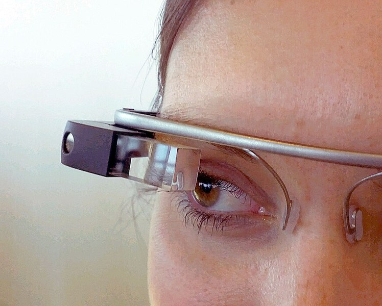Close up of someone's eye looking through a Google Glass device.