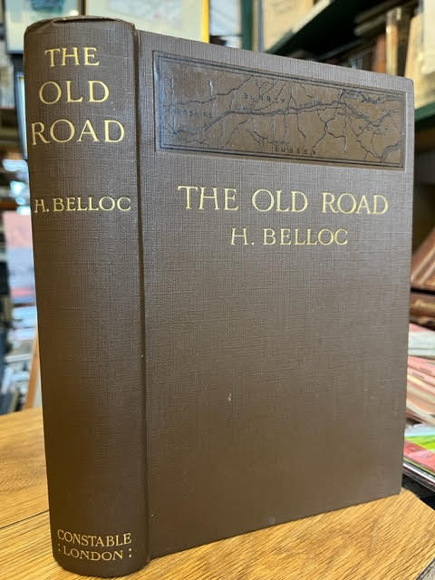 A old book, green with gold writing, The Old Road H. Belloc it features a brown map on the top third of the book