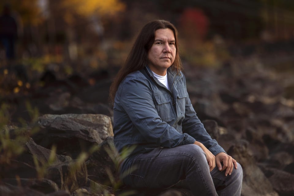 First Nations author sitting in a forest