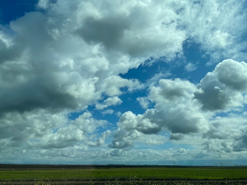 a cloudy sky over a field