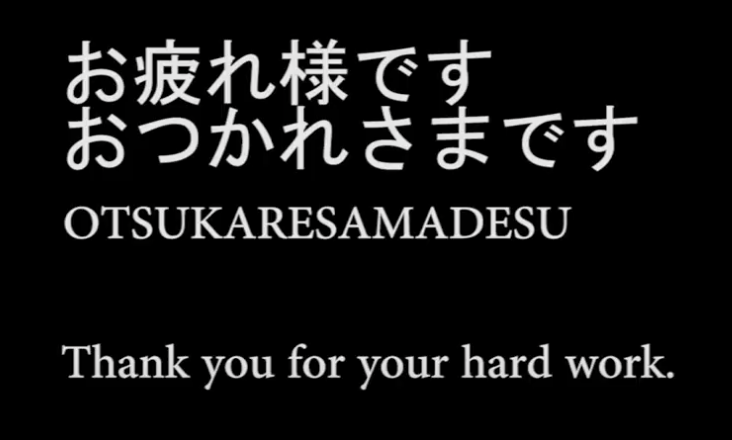 White text on a black background. There are two lines of Japanese characters with the English phonetic spelling underneath. It reads, "OTSUKARESAMADESU". Underneath this is the English meaning of the phrase. It reads, "Thank you for your hard work."