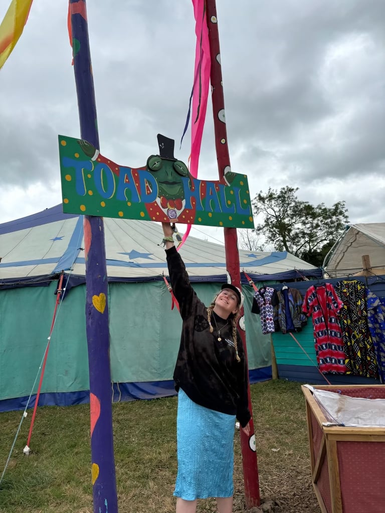 a woman holding up a sign at a festival