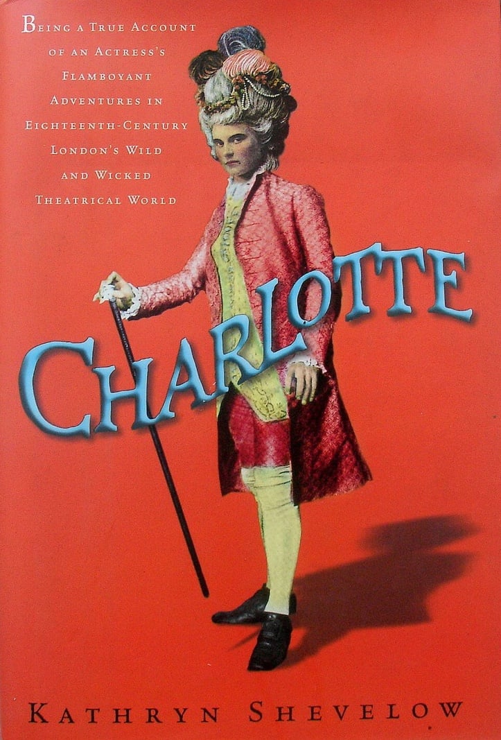 The cover of Charlotte by Kathryn Shevelow, depicting a masc person wearing an elaborate wig and fancy Georgian clothes with a cane, against a red background
