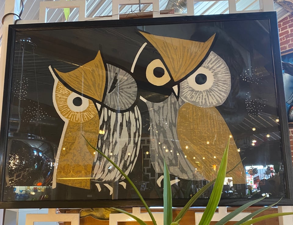 A midcentury woodblock print of two owls, one of which is winking one eye
