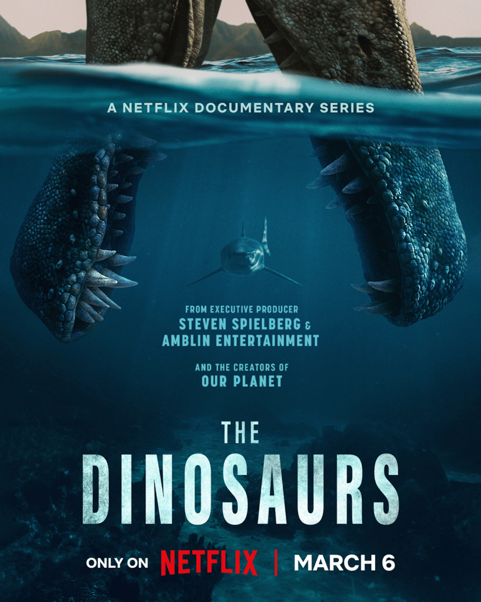 The poster for The Dinosaurs, showing gaping Spinosaurus jaws underwater with a shark swimming towards them. The text says "From executive producer Steven Spielberg & Amblin Entertainment and the creators of Our Planet, The Dinosaurs only on Netflix March 6"