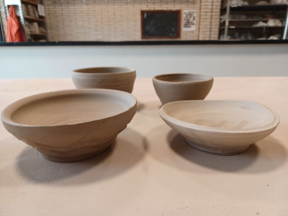 three wonky, unglazed wheel-thrown pots
