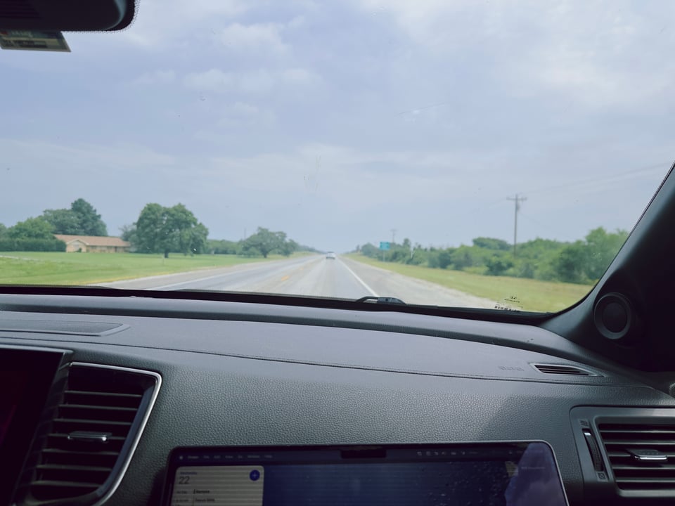 A little bit of laptop screen, some highway, and a whole bunch of sky.