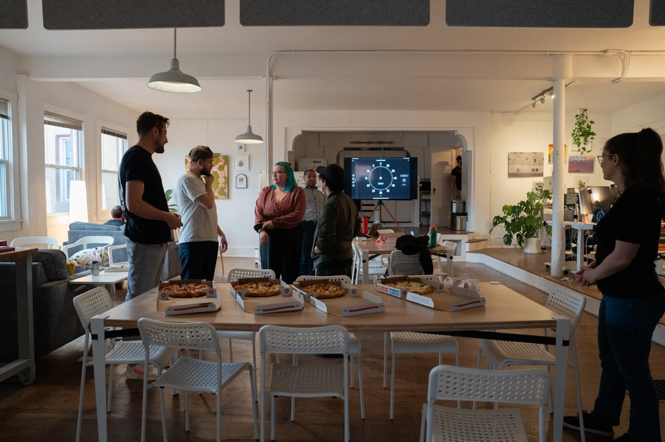 People approaching some pizzas.