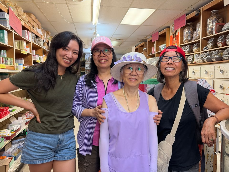 Four Asian women in a range of ages pose and smile for photo in a herb store in Chinatown.