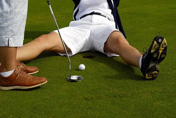 A weird stock photo I found of someone about to putt a golf ball into a hole, but with another person's legs spread open around the hole.