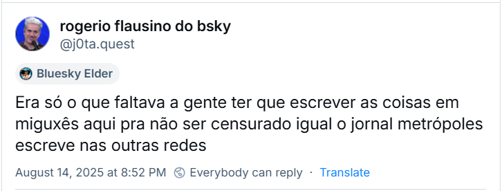A imagem mostra post do rogerio flausino do bsky (‪@j0ta.quest‬) com o texto: Era só o que faltava a gente ter que escrever as coisas em miguxês aqui pra não ser censurado igual o jornal metrópoles escreve nas outras redes