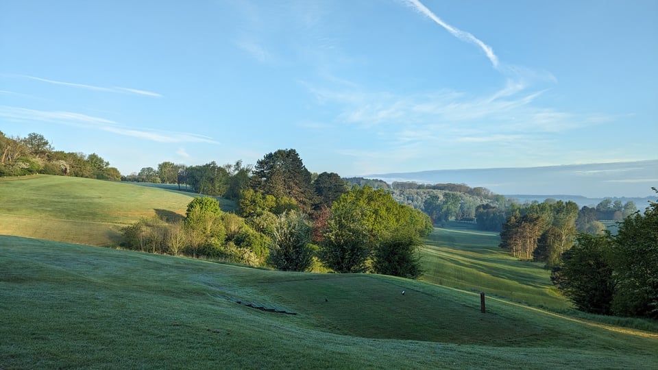 Rushcliffe, May 2024, 1st hole white tee box, sloping fairway out on the left, 15th fairway coming back on the right