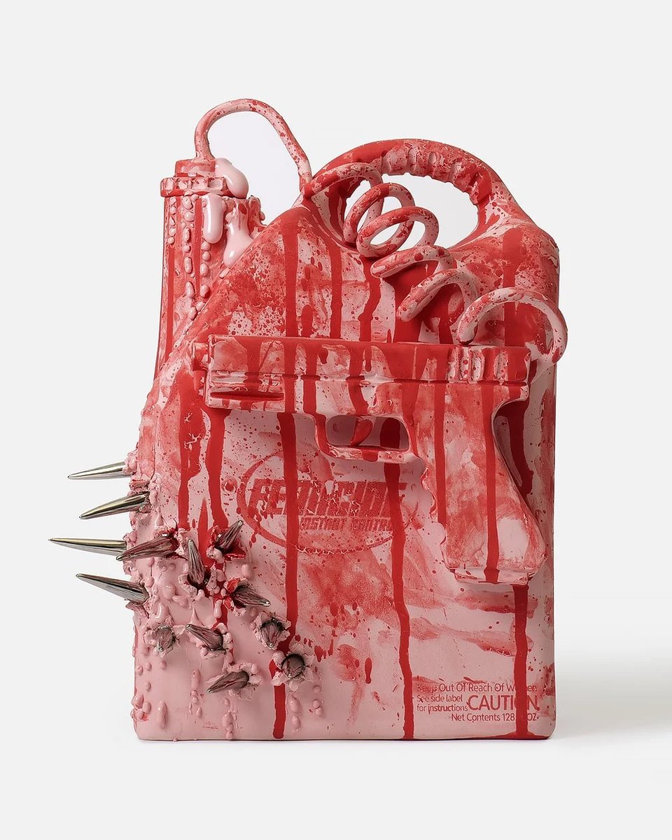 A sculptural art object resembling a pink and red backpack or detergent jug, covered in dripping red paint, with metal spikes protruding from its left side, coiled tube-like handles on top, and small printed text reading "CAUTION" and "Net Contents 128 fl oz" near the bottom right, photographed against a plain white background.