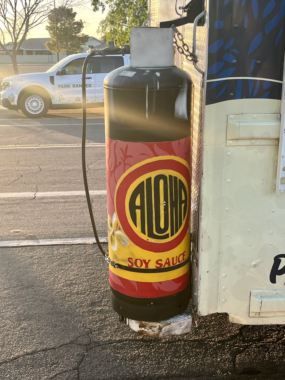 A fuel tank attached to the back of a food truck. the fuel tank is painted to look like a bottle of soy sauce.