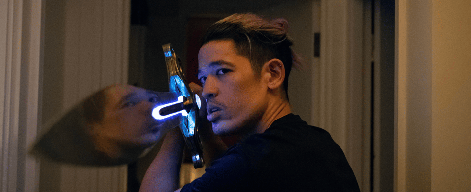 A still from Slow Horses, season 5. Roddy Ho (played by Christopher Chung) wields a ridiculous, light up sword in a corridor.