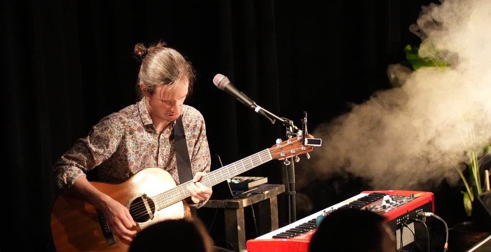 A man (Markus) playing an acoustic guitar