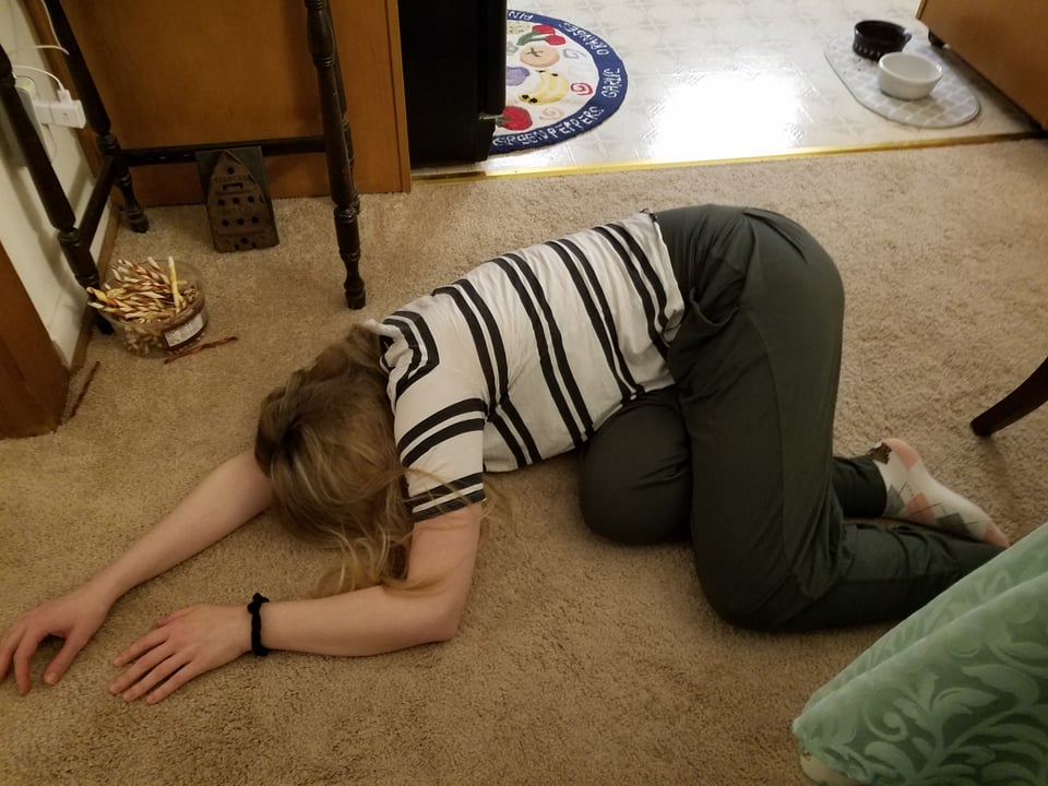 A photo of Emily in 2021 lying down on the ground out of sheer overwhelm.