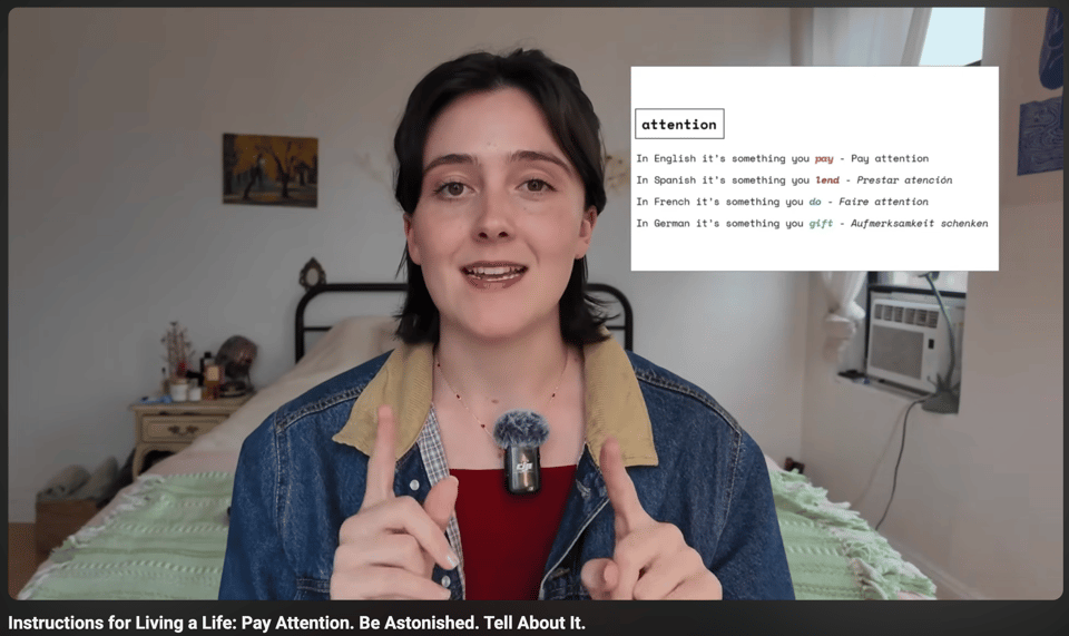 Screenshot of a YouTube video: "Instructions for Living a Life: Pay Attention, Be Astonished. Tell About It." Anna Howard, a white-presenting 20-something sits in front of her bed with a microphone. Inset is "attention" with 4 different translations in 4 different languages.