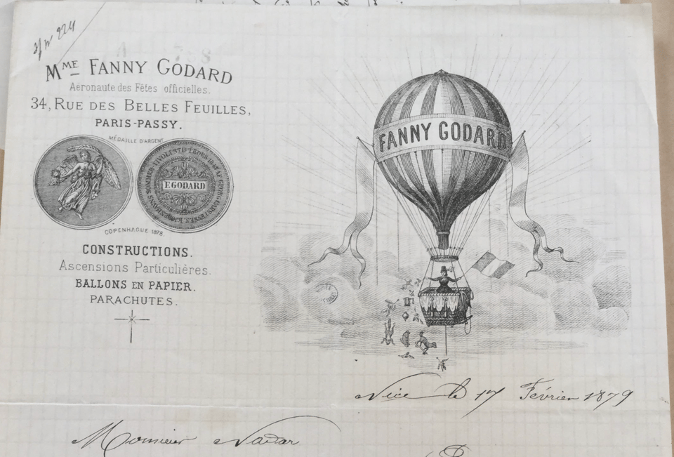Printed letterhead for Fanny Godard. The image in black hows a balloon with a female aeronaut holding a flag. Also visible at left are two medals outlining Godard's accomplishments.