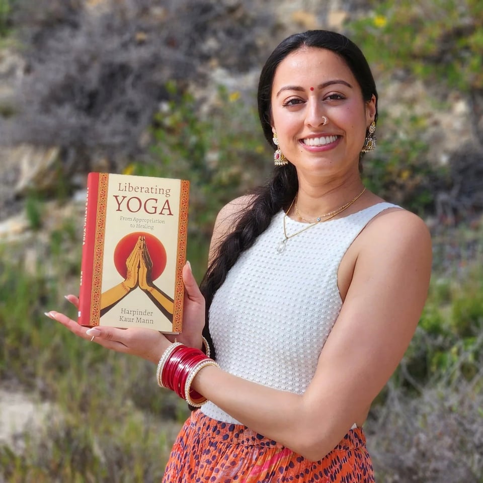 Harpinder Mann holding her book and smiling at the camera