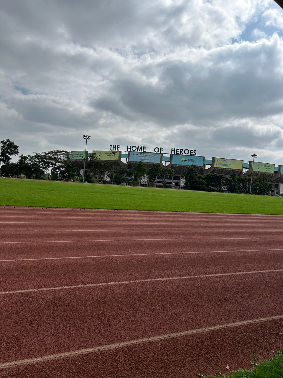 A photo of a track, and in the background you can see a stadium that has the words "HOME OF HEROES" at the top of it.