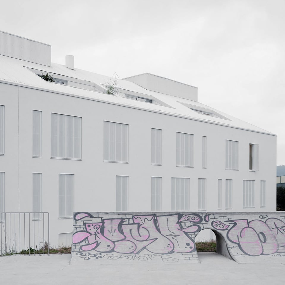facade of the alto residential coop with some graffiti in the foreground