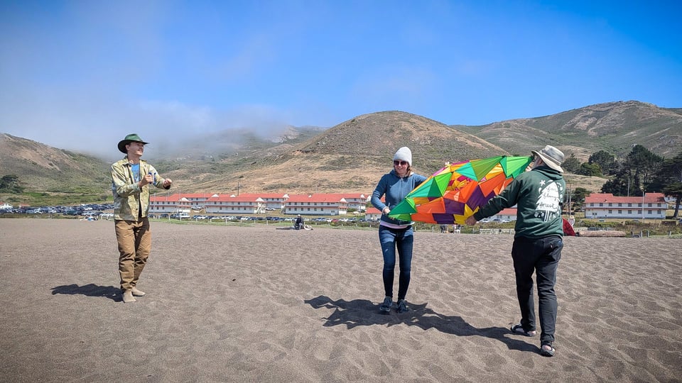 Lex, Denorae, and Deprong Mori set up the beach kite!