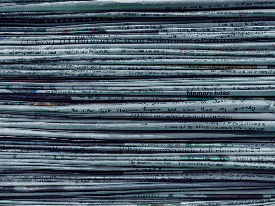A close-up of a stack of newspapers. Photo by Utsav Srestha on Unsplash.