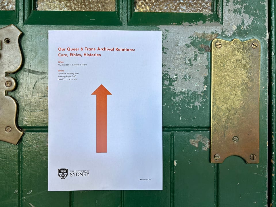 An A4 signage for Our Queer and Trans Archival Relations: Care, Ethics, Histories workshop held on March 12, 2025, at the University of Sydney RD Watt building. The white signage with a red arrow contrasts the building entrance door in green.