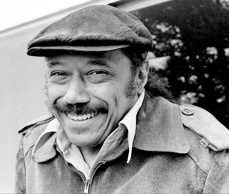 Horace Silver smiling. He's a man in a jacket and wearing a flat cap.