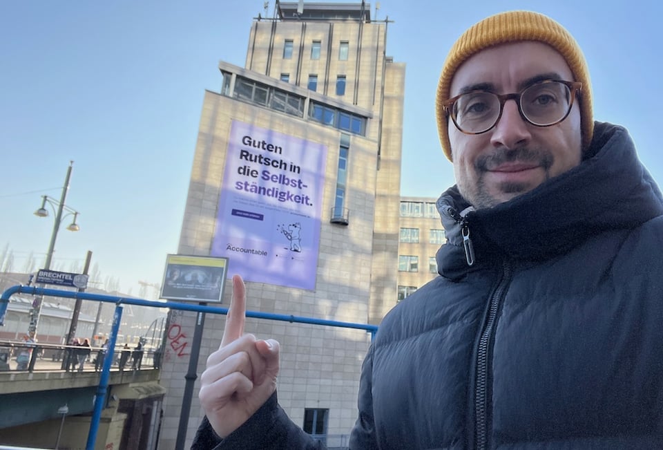 The newsletter author pointing at the Accountable billboard at Warschauer straße