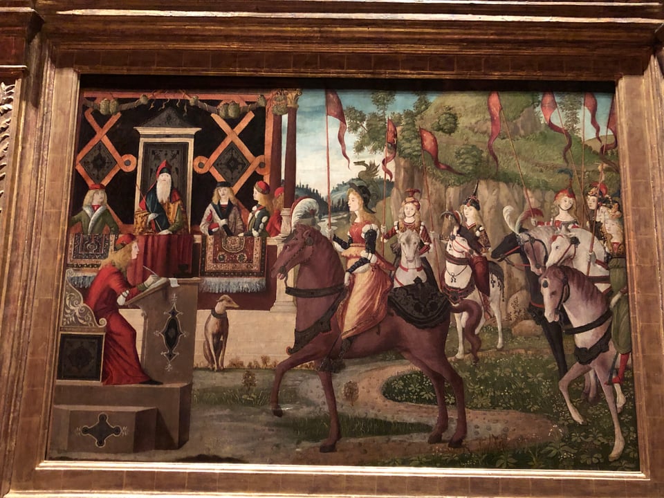 A Renaissance painting showing a group of finely dressed women on horseback approaching a regal-looking fellow on an outdoor throne thing, surrounded by a few courtiers, all finely dressed. A scribe sits at a desk, eagerly observing and taking notes. An elegant greyhound, seated, watches patiently.
