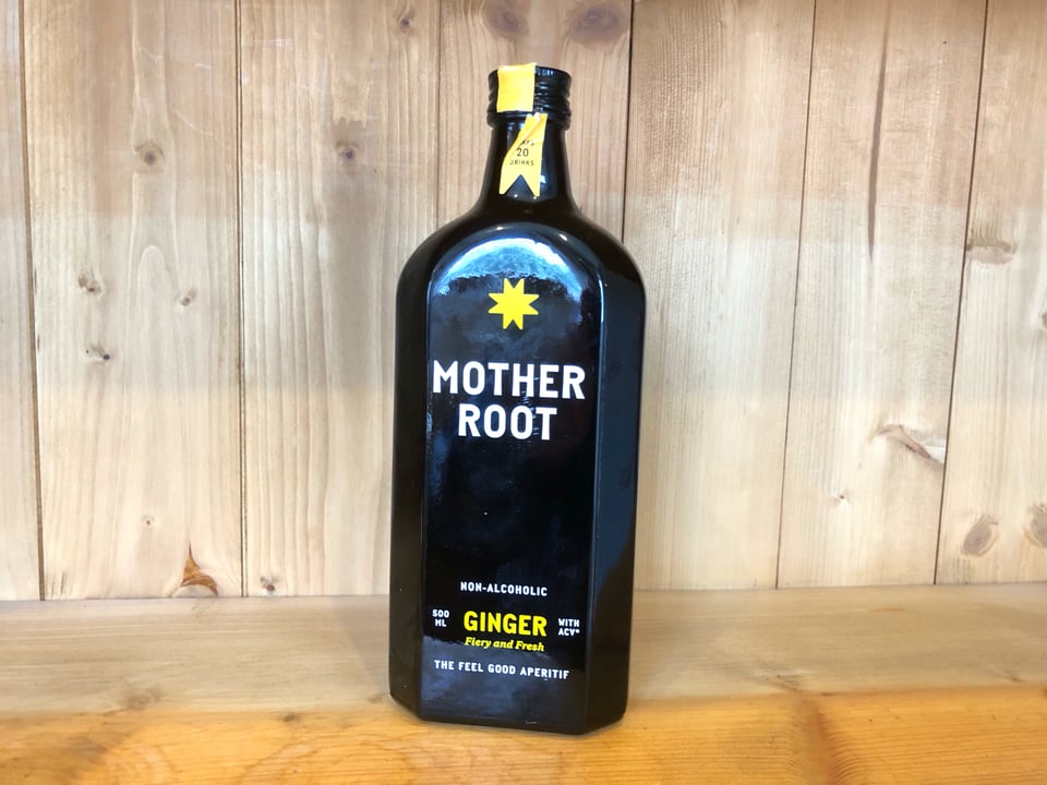 Photograph of a bottle of Mother Root non-alcoholic ginger aperitif, standing on a bookshelf.