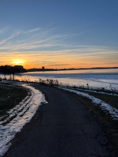 blue gold sunset over a turn in the path along the partially frozen lake