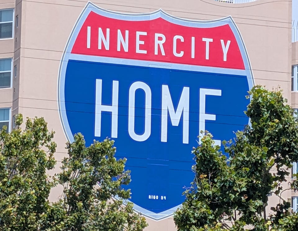 Mural says "INNERCITY HOME" in a red and blue shield