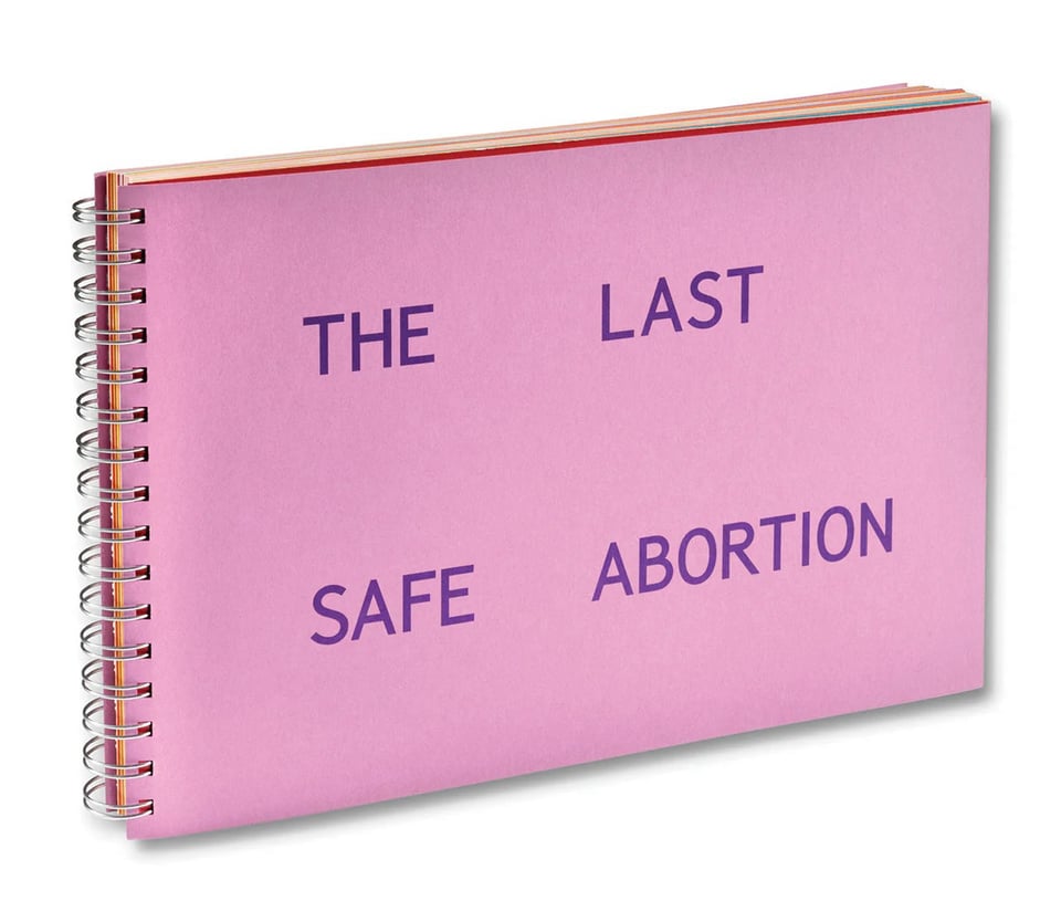 A pink spiral-bound horizontal book with purple, all-caps text reading "The Last Safe Abortion"