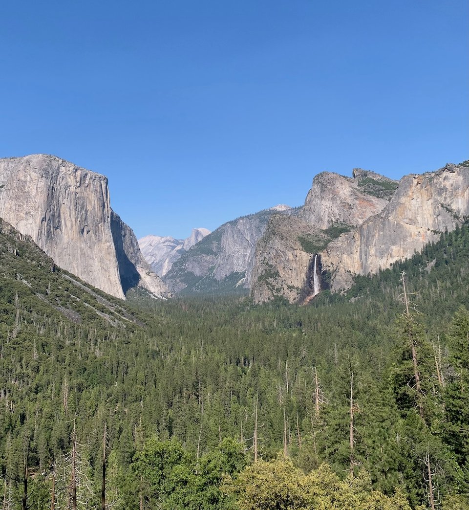 a view of the yosemite valley with a waterfall on the right