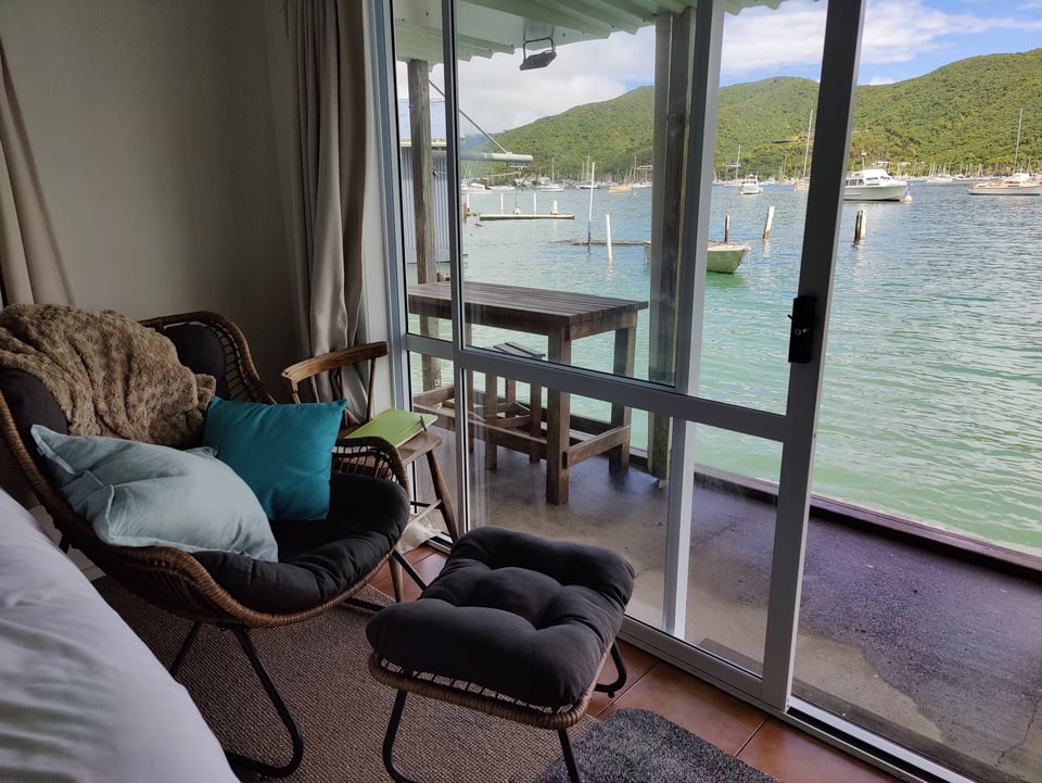 image of chair in front of open sliding glass door, gorgeous blue water lapping outside