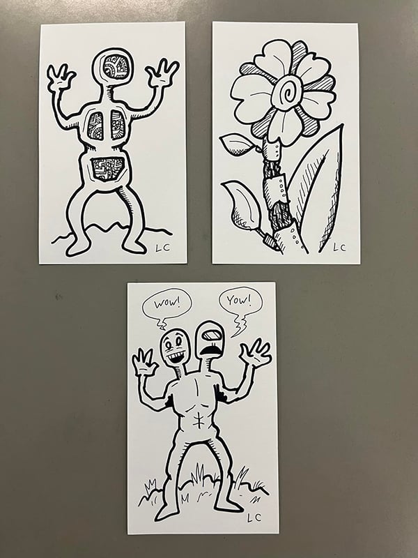 Three index card drawings; two humanoid creatures and one flower