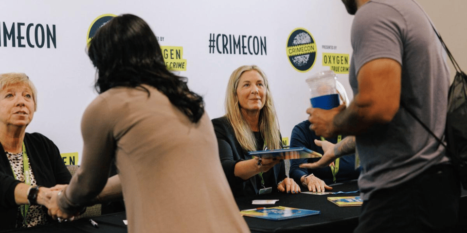 Attendees of CrimeCon get books signed.