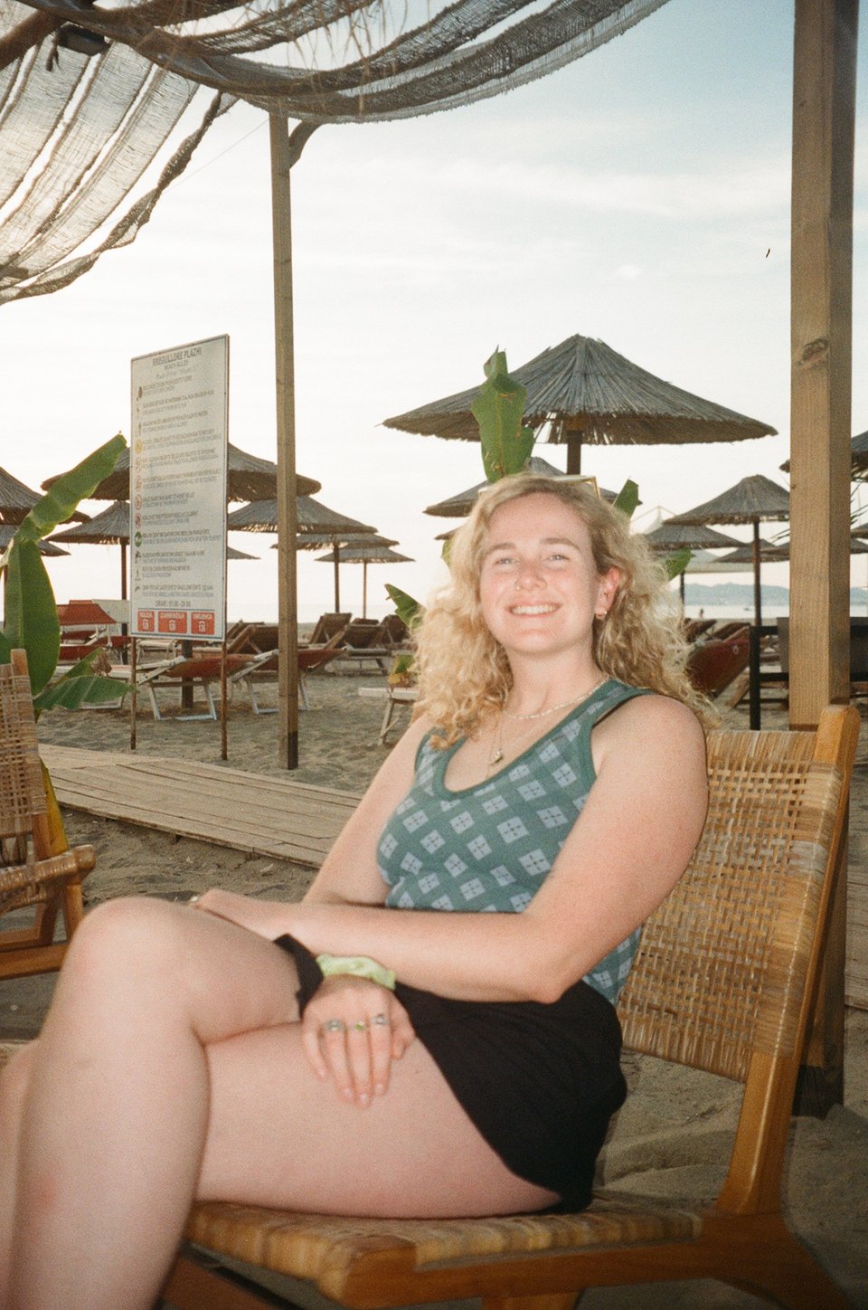 a woman sitting in a chair on a beach