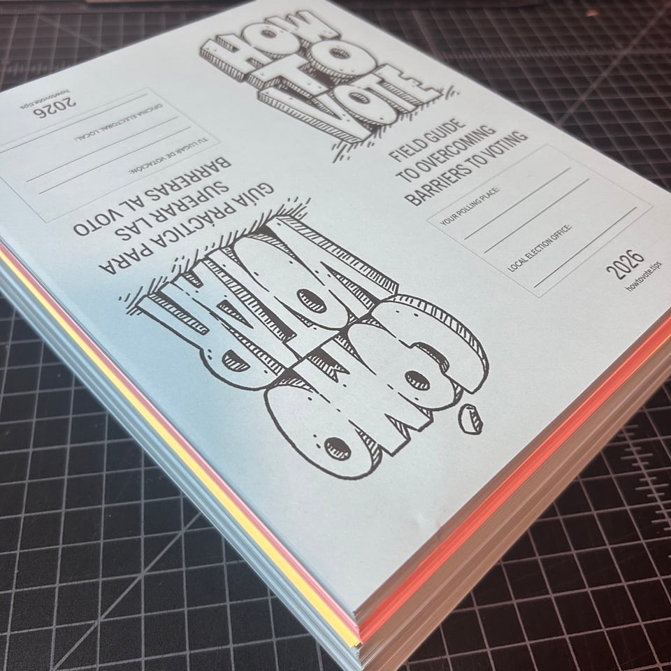 A giant stack of HOW TO VOTE/COMO VOTAR zines that need to get folded.