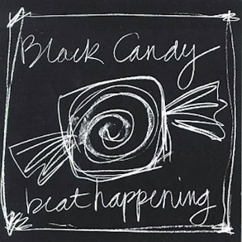 A blackboard. In chalk, "Black Candy" is written on the top and "beat happening" on the bottom. In the middle is a loose sketch of a square piece of candy in a wrapper. It has a sprial shape in the middle of it.