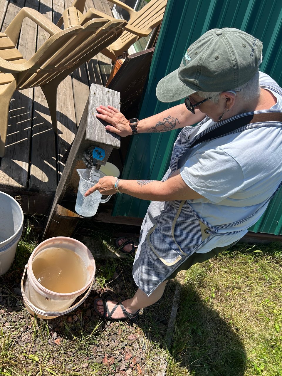 Leslie filling a bucket with water at visitor center art camp