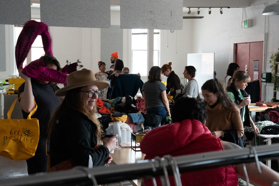 A room of people looking at clothes.