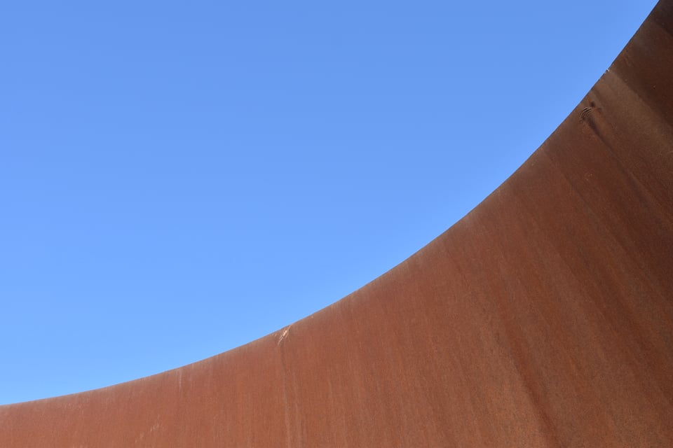 a rusty metal wall against a blue sky